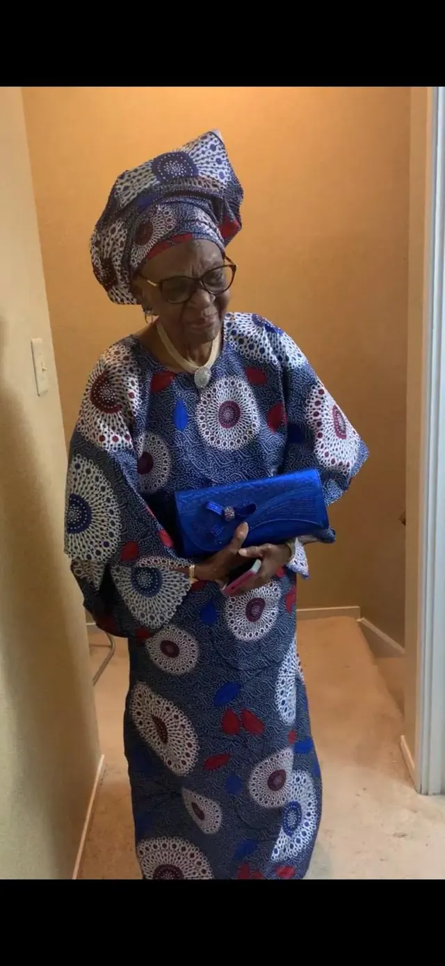 Deaconess Victoria Badejoko Lawoyin standing in a blue, white, and red patterned ankara outfit with a matching gele.